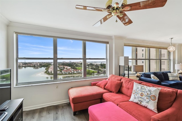 living room with wood-type flooring, a water view, ceiling fan, and crown molding