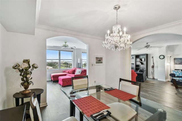 dining area featuring ornamental molding, ceiling fan with notable chandelier, and hardwood / wood-style floors