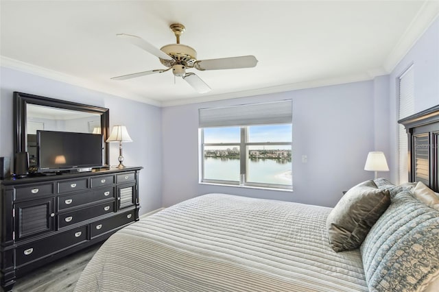 bedroom with ceiling fan, ornamental molding, and wood-type flooring