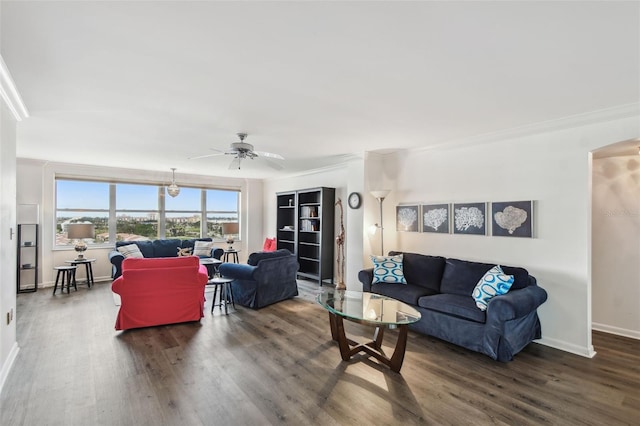 living room featuring ceiling fan, ornamental molding, and dark hardwood / wood-style flooring