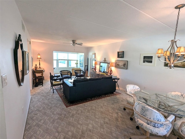 carpeted living room featuring ceiling fan with notable chandelier