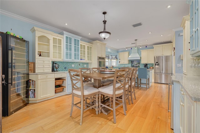 dining room featuring light wood-type flooring and crown molding