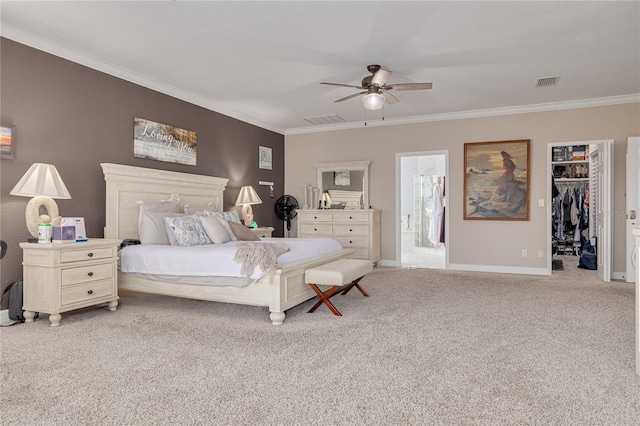 bedroom with ceiling fan, ensuite bathroom, light colored carpet, a walk in closet, and a closet