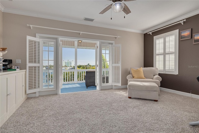 sitting room featuring carpet, ceiling fan, and crown molding