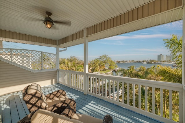 wooden deck with a water view and ceiling fan