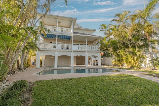 back of property with a balcony and a lawn