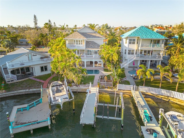 238 71st Ave, St Pete Beach, FL 33706 - dock area with a water view, a patio area, boat lift, a balcony, and a fenced in pool