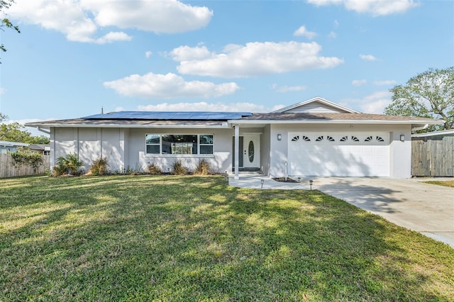 ranch-style home with a front lawn, a garage, and solar panels