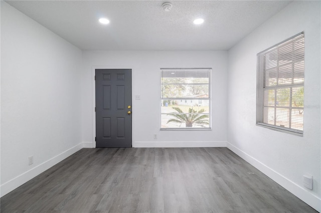 unfurnished room with dark hardwood / wood-style floors and a textured ceiling