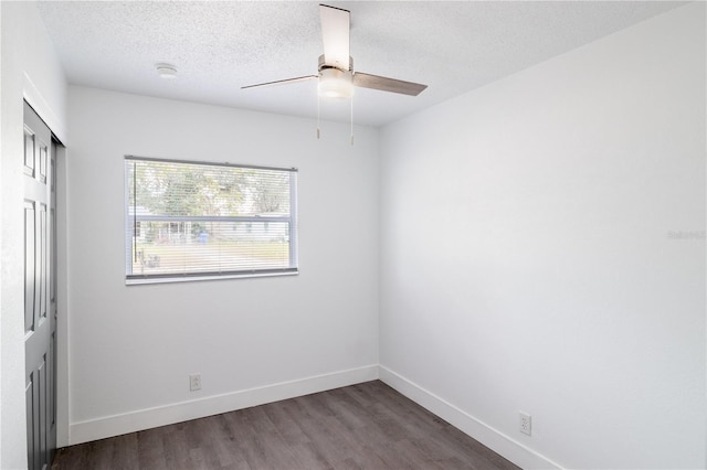 empty room featuring dark wood-type flooring, a textured ceiling, and ceiling fan