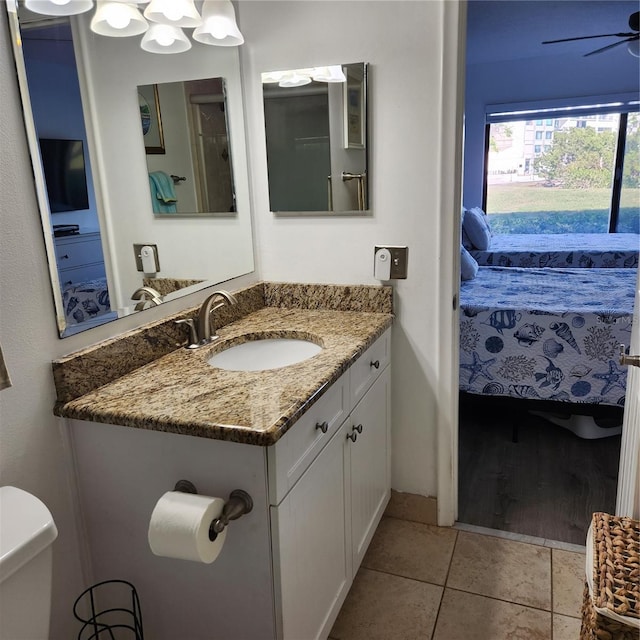 bathroom featuring tile patterned flooring, vanity, ceiling fan, and toilet