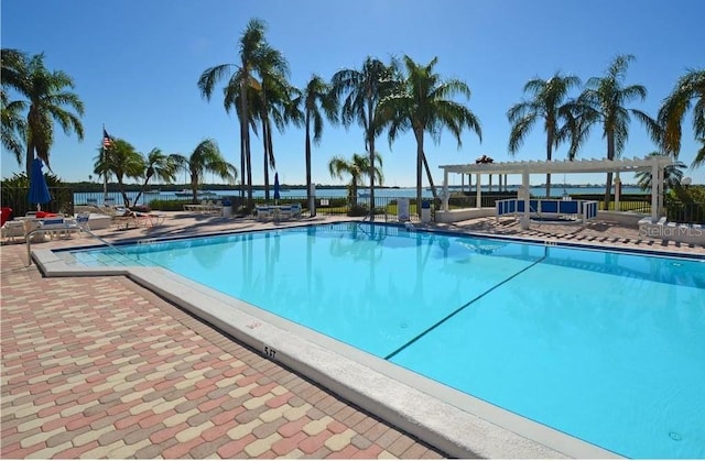 view of pool featuring a pergola, a patio area, and a water view