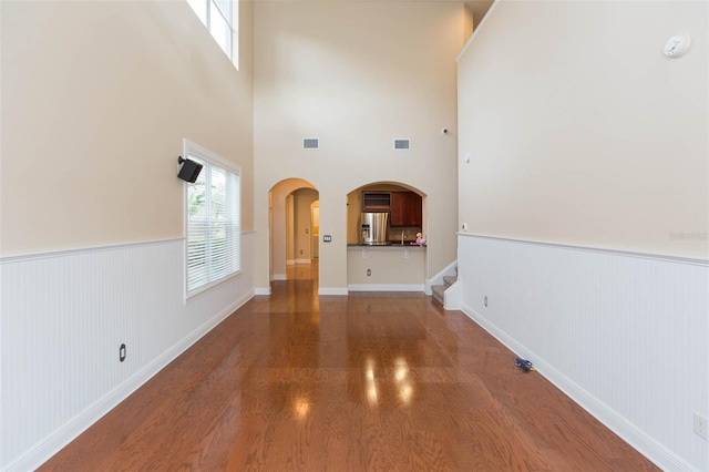 unfurnished living room with a towering ceiling