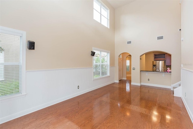 unfurnished living room with a towering ceiling