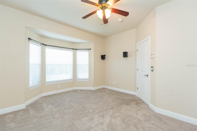 carpeted empty room featuring ceiling fan