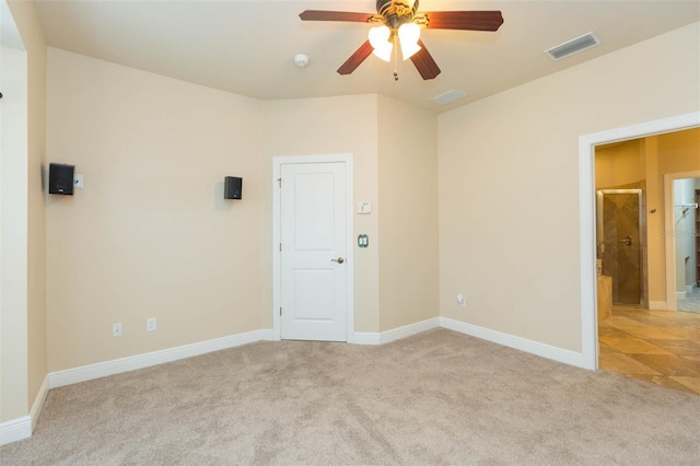 spare room featuring light carpet and ceiling fan