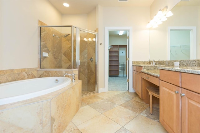 bathroom with vanity and shower with separate bathtub