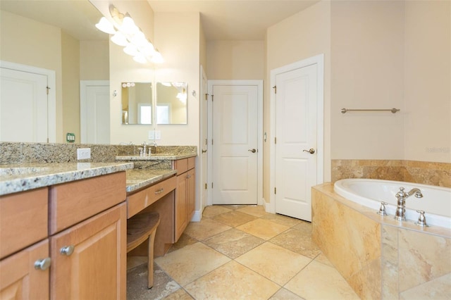 bathroom featuring tiled tub and vanity