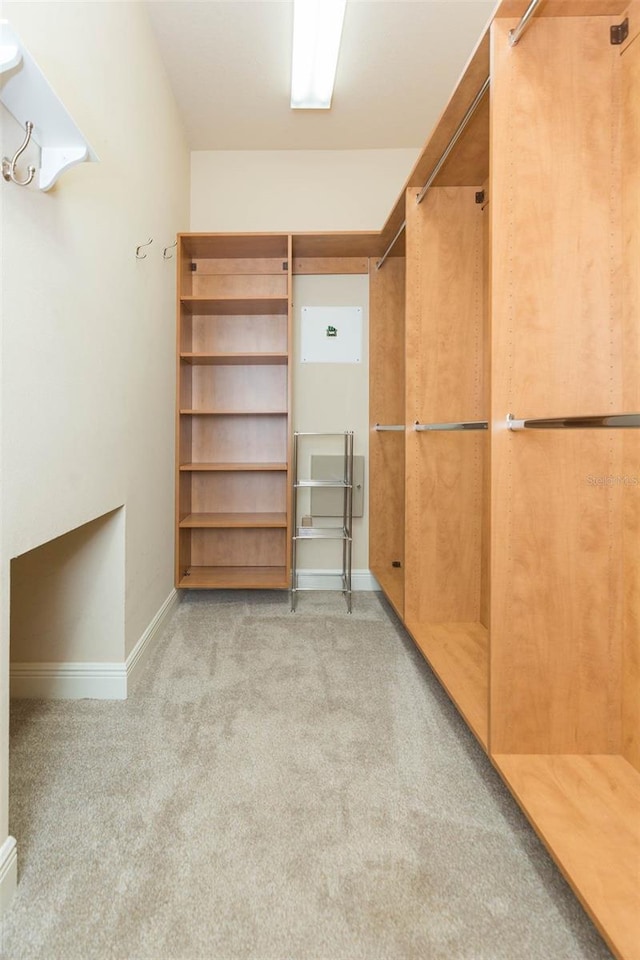 walk in closet featuring light carpet