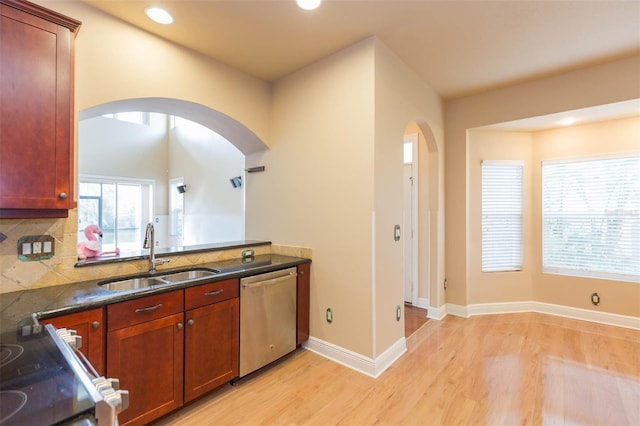 kitchen featuring dishwasher, sink, light wood-type flooring, decorative backsplash, and range