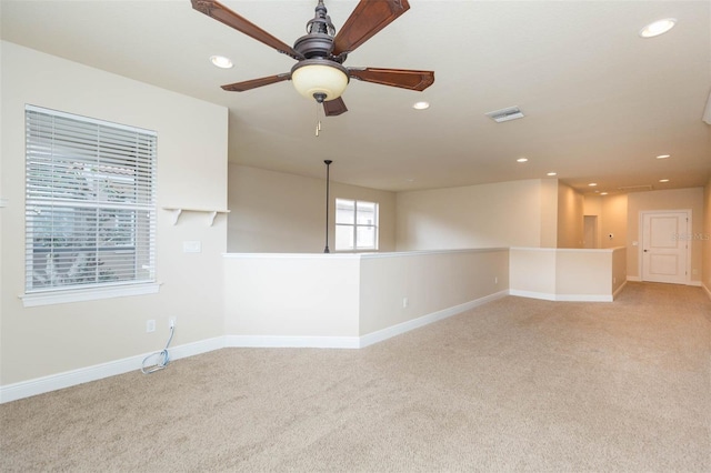 spare room featuring light carpet and ceiling fan