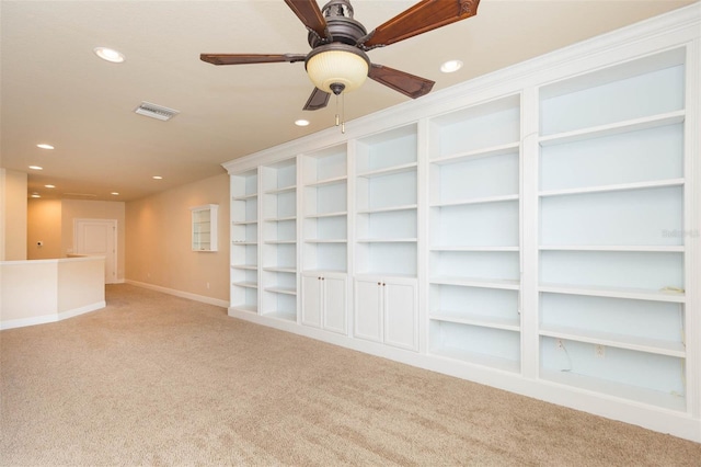 carpeted spare room featuring built in features and ceiling fan