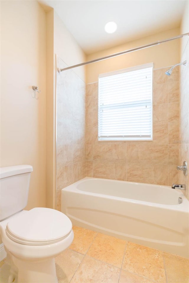 bathroom with tiled shower / bath and toilet