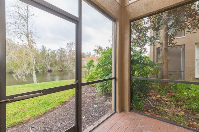 unfurnished sunroom featuring a water view