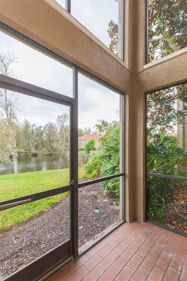 unfurnished sunroom featuring a water view