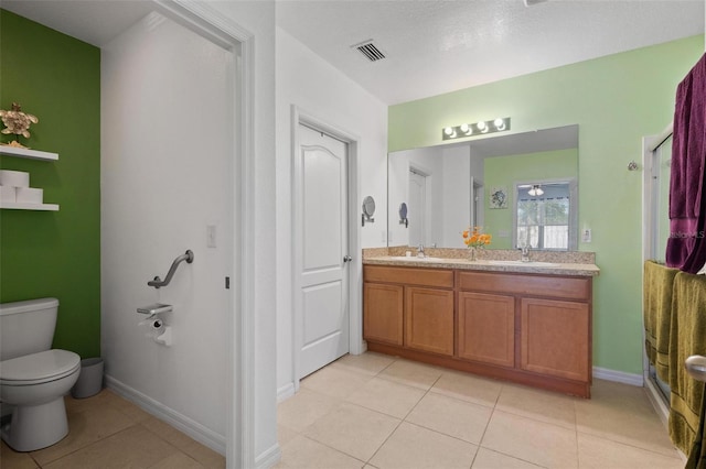 bathroom featuring tile patterned flooring, vanity, a shower with door, and toilet