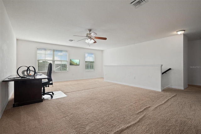 office featuring a wealth of natural light, ceiling fan, and light carpet