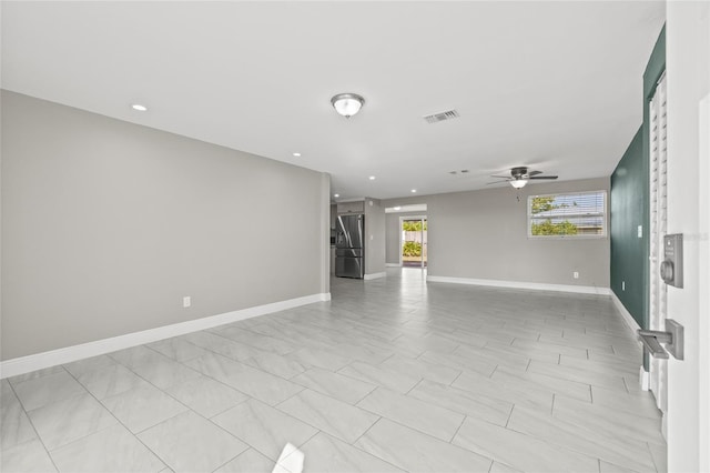 tiled spare room featuring ceiling fan