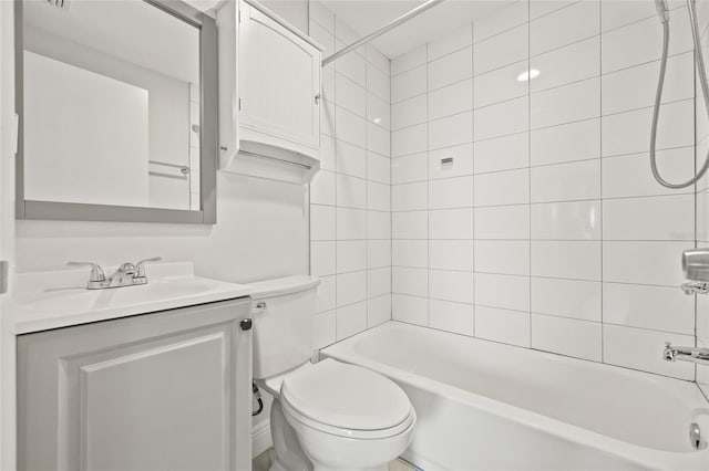 full bathroom featuring vanity, tiled shower / bath combo, and toilet