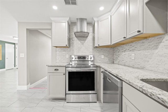 kitchen featuring appliances with stainless steel finishes, backsplash, white cabinetry, and wall chimney range hood