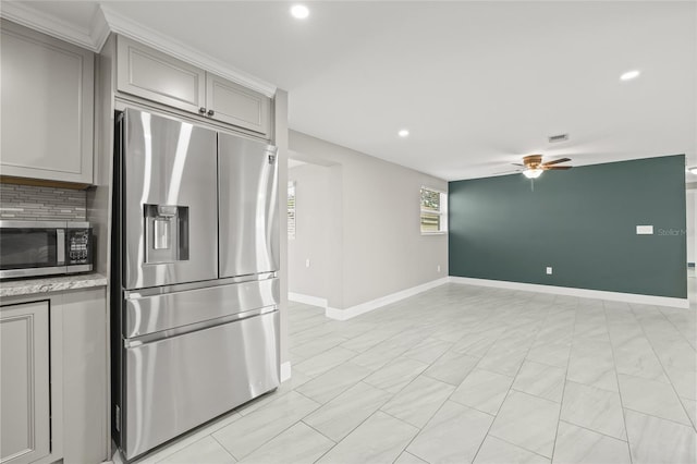 kitchen featuring gray cabinetry, decorative backsplash, ceiling fan, and stainless steel appliances