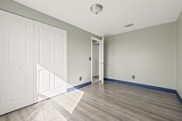 unfurnished bedroom featuring hardwood / wood-style flooring and a closet