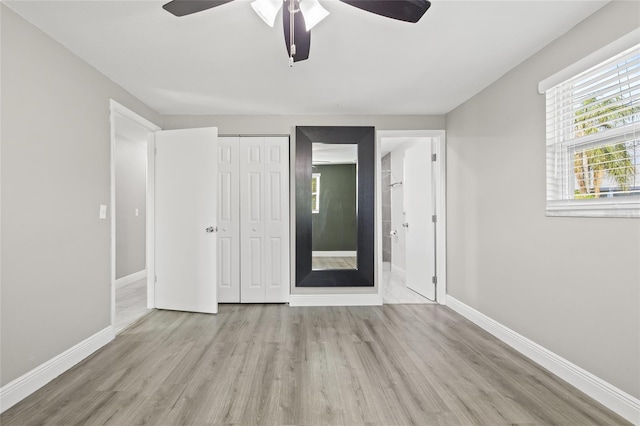 unfurnished bedroom featuring ceiling fan, light wood-type flooring, and a closet