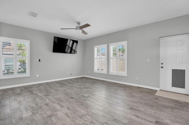 unfurnished living room featuring light wood-type flooring, ceiling fan, and a healthy amount of sunlight