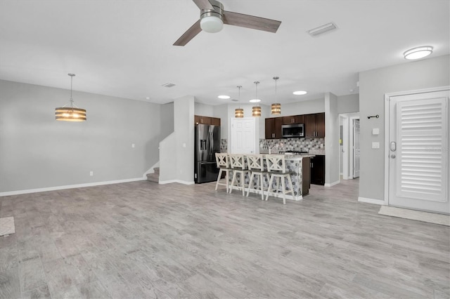 kitchen featuring a center island, stainless steel appliances, a kitchen breakfast bar, tasteful backsplash, and pendant lighting