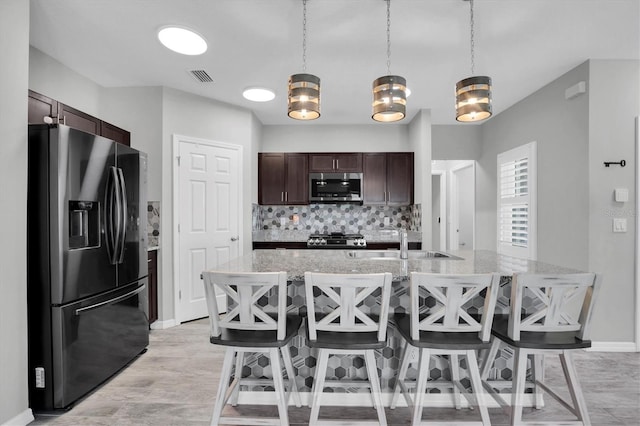 kitchen with decorative backsplash, stainless steel appliances, sink, a notable chandelier, and hanging light fixtures