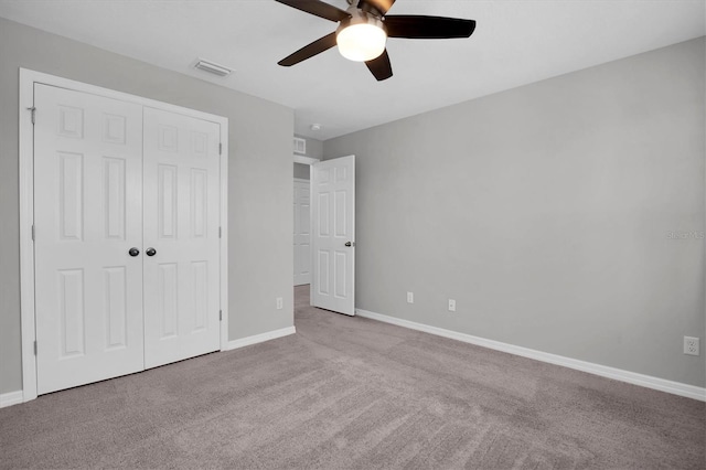 unfurnished bedroom featuring a closet, light colored carpet, and ceiling fan