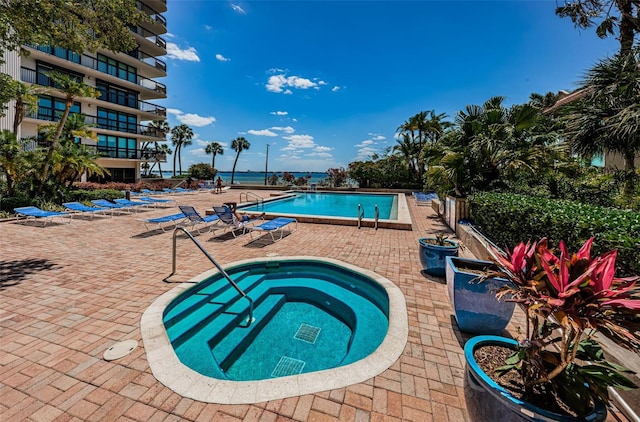 view of pool with a community hot tub and a patio