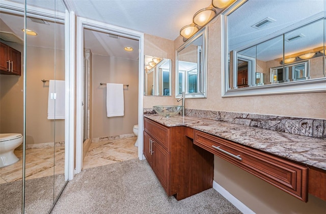 bathroom with toilet, an enclosed shower, vanity, and a textured ceiling