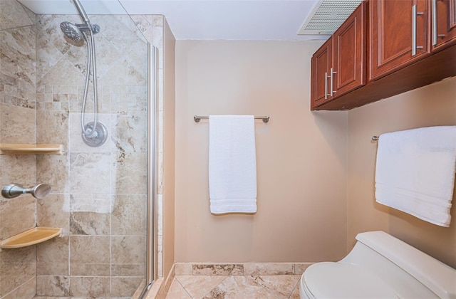 bathroom with a shower with shower door and toilet