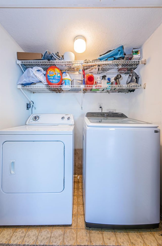 laundry room featuring a textured ceiling and separate washer and dryer