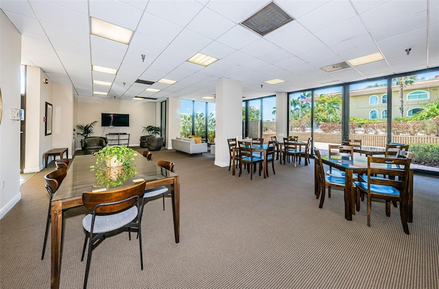 carpeted dining area featuring expansive windows