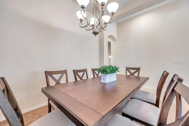 carpeted dining room featuring a notable chandelier