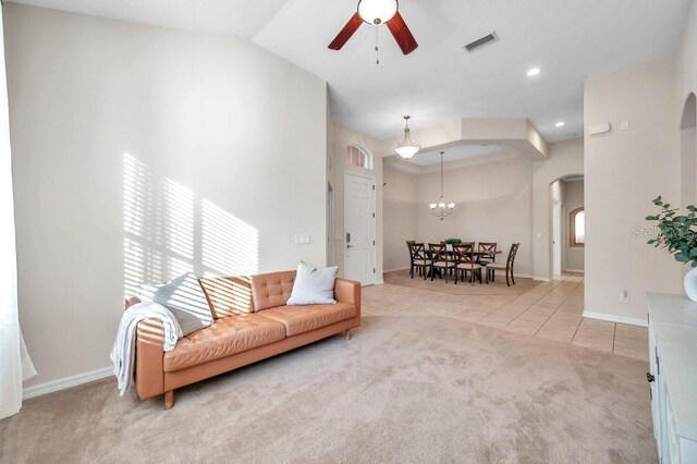 living room featuring ceiling fan, light tile patterned floors, and lofted ceiling