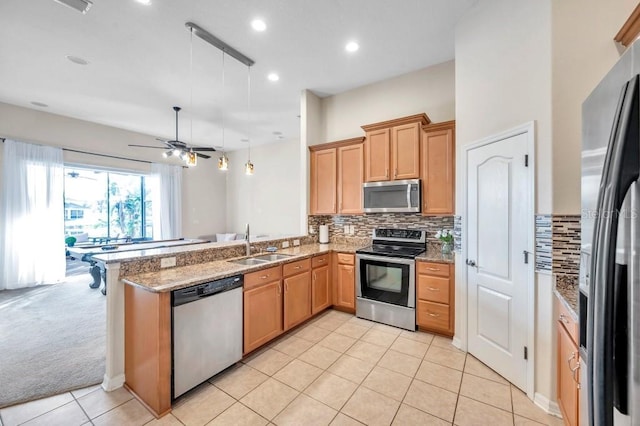 kitchen featuring kitchen peninsula, ceiling fan, sink, and appliances with stainless steel finishes