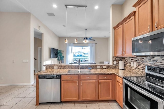 kitchen featuring ceiling fan, sink, hanging light fixtures, stainless steel appliances, and kitchen peninsula